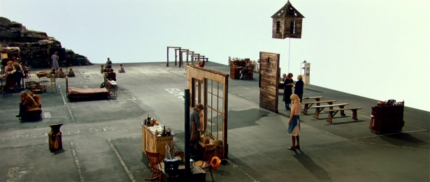 Image tirée du film “Dogville”. Lars Von Trier suggère le décor d'un village dans son film. L'imaginaire du spectateur suffit à incarner les murs et les meubles des maisons.