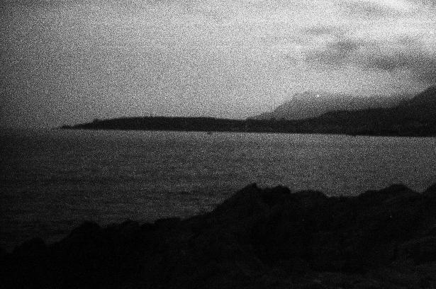Photographie noir et blanc de la baie de Menton, vue depuis la plage de Vintimille