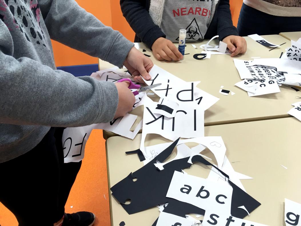 Les élèves s'empressent de découper des lettres et des mots pour être les prochains à passer