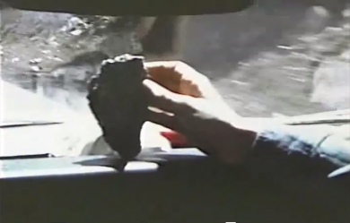 Capture d’écran du film « Mono Lake », réalisé par Nancy Holt et Robert Smithson (1968-2004, 19’54, son). Ce dernier tient en main une roche prélevée en retour d’exploration au bord du lac Mono.